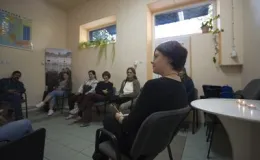 zdjęcie grupy osób siedzących w kręgu podczas spotkania w kameralnym pomieszczeniu