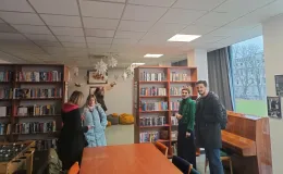Zdjęcie przedstawiające grupę ludzi w bibliotece 