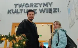 Zdjęcie przedstawiające dwie osoby stojące przed wejściem do pomieszczenia.