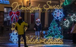 na zdjęciu ozdobione miasto i osoby podczas rozświetlenia