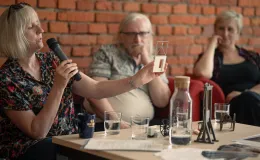 Na zdjęciu trzy siedzące osoby