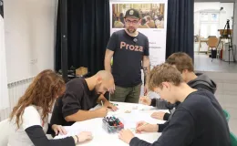 Zdjecie grupy osób rysujących na kartkach.