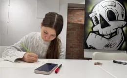 Zdjecie dzieczyny rysującej na kartce.