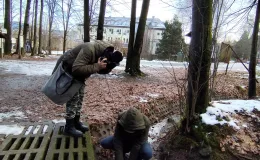 Person wearing headphones, listening to the recorded sound of a forest stream.