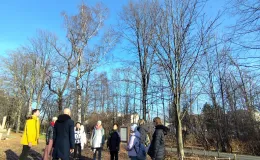Group of people standing opposite each other with closed eyes during a mindfulness exercise led by a local musician. They are listening to the surrounding nature.