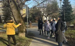 Participants standing beside a magnificent tree, listening to the explanations of the municipal gardener.