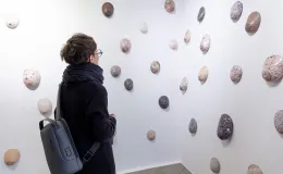 Osoby na wystawie oglądają prace