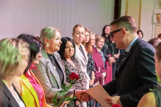 na zdjęciu osoby przemawiające ze sceny