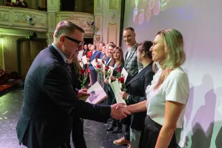 na zdjęciu osoby przemawiające ze sceny