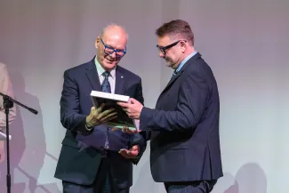 na zdjęciu osoby przemawiające ze sceny