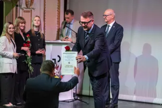 na zdjęciu osoby przemawiające ze sceny