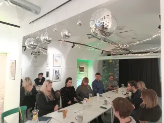 Zdjęcie przedstawiające osoby siedzące przy stole w Punkcie 11.