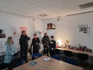 Zdjęcie przedstawiające grupę osób w pomieszczeniu.