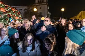 na zdjęciu ozdobione miasto i osoby podczas rozświetlenia