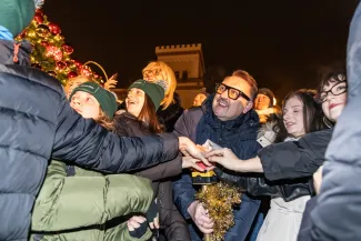 na zdjęciu ozdobione miasto i osoby podczas rozświetlenia