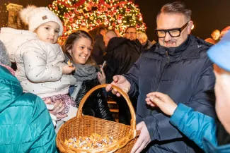 na zdjęciu ozdobione miasto i osoby podczas rozświetlenia