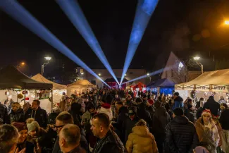 na zdjęciu ozdobione miasto i osoby podczas rozświetlenia