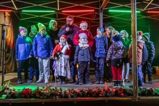 na zdjęciu ozdobione miasto i osoby podczas rozświetlenia