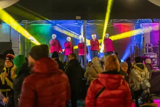 na zdjęciu ozdobione miasto i osoby podczas rozświetlenia