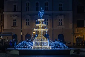 na zdjęciu ozdobione miasto i osoby podczas rozświetlenia