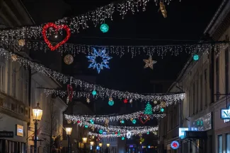 na zdjęciu ozdobione miasto i osoby podczas rozświetlenia