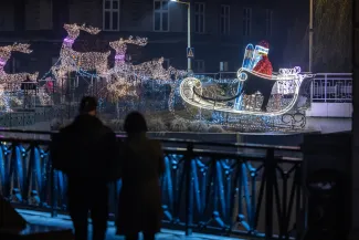 na zdjęciu ozdobione miasto i osoby podczas rozświetlenia