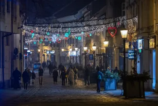 na zdjęciu ozdobione miasto i osoby podczas rozświetlenia
