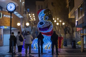 na zdjęciu ozdobione miasto i osoby podczas rozświetlenia
