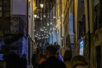 na zdjęciu ozdobione miasto i osoby podczas rozświetlenia
