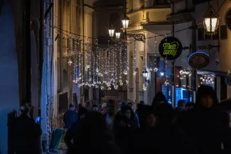 na zdjęciu ozdobione miasto i osoby podczas rozświetlenia