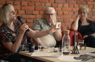 Na zdjęciu trzy siedzące osoby