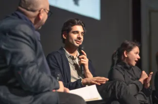 Na zdjęciu trzy siedzące osoby