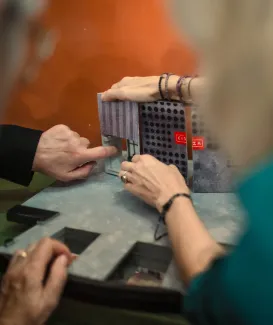 Na zdjęciu ręce dotykające makiety teatralnej