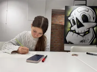 Zdjecie dzieczyny rysującej na kartce.