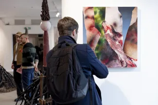 Osoby na wystawie oglądają prace