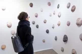 Osoby na wystawie oglądają prace