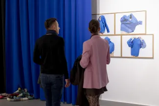 Osoby na wystawie oglądają prace
