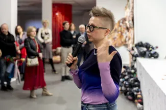 Osoby na wystawie oglądają prace