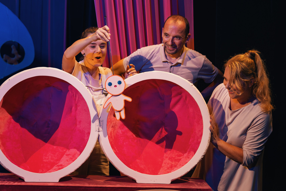 Na zdjęciu troje aktorów przy otwartej kuli