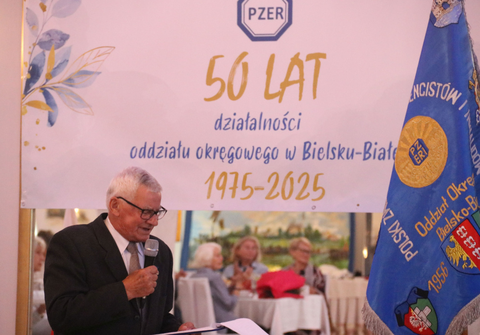 Na zdjęciu stojący ludzie 