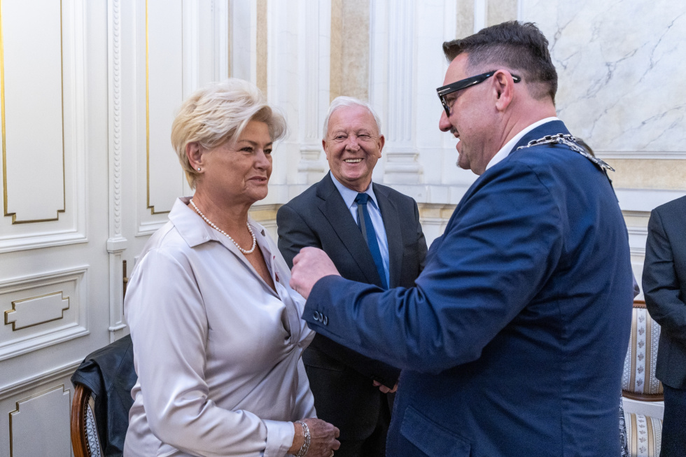 Na zdjęciu stojący ludzie 