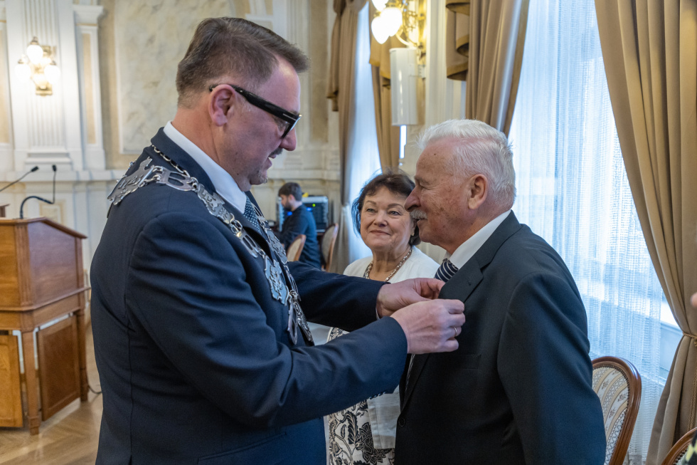 Na zdjęciu stojący ludzie 