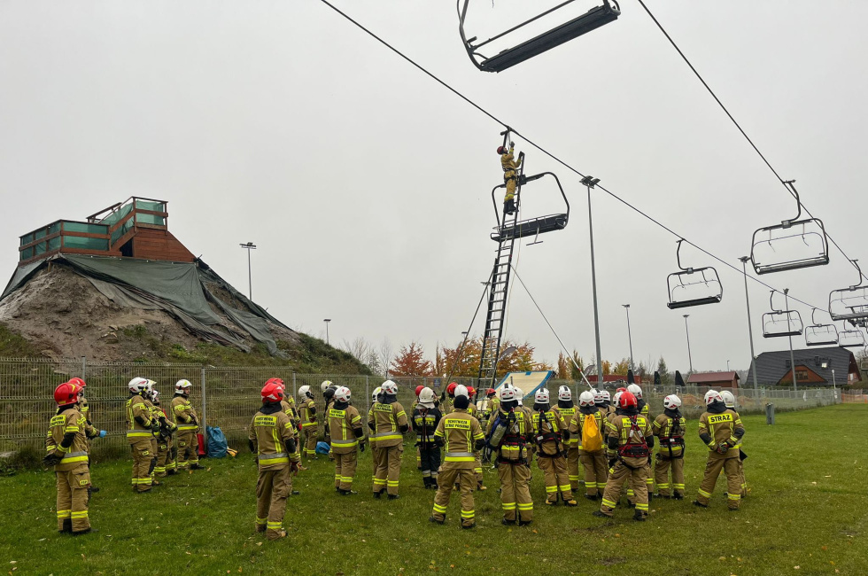 Na zdjęciu stojący ludzie 
