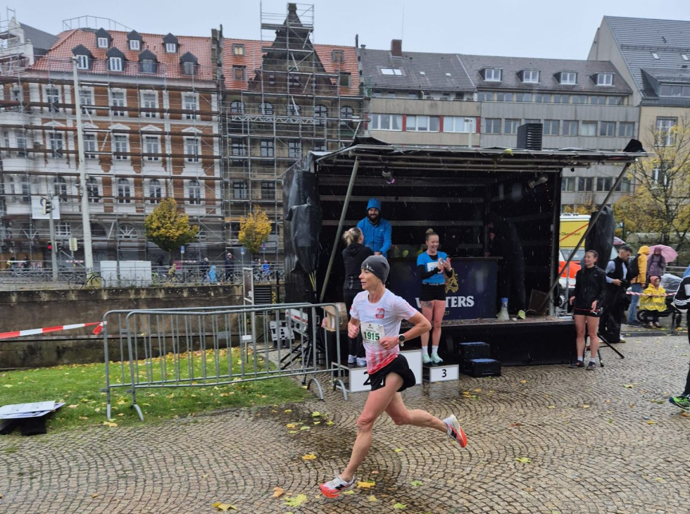 Na zdjęciu stojący ludzie 