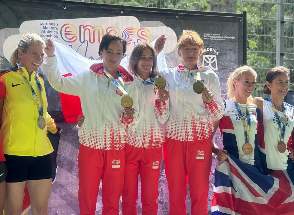 Na zdjęciu stojący ludzie 