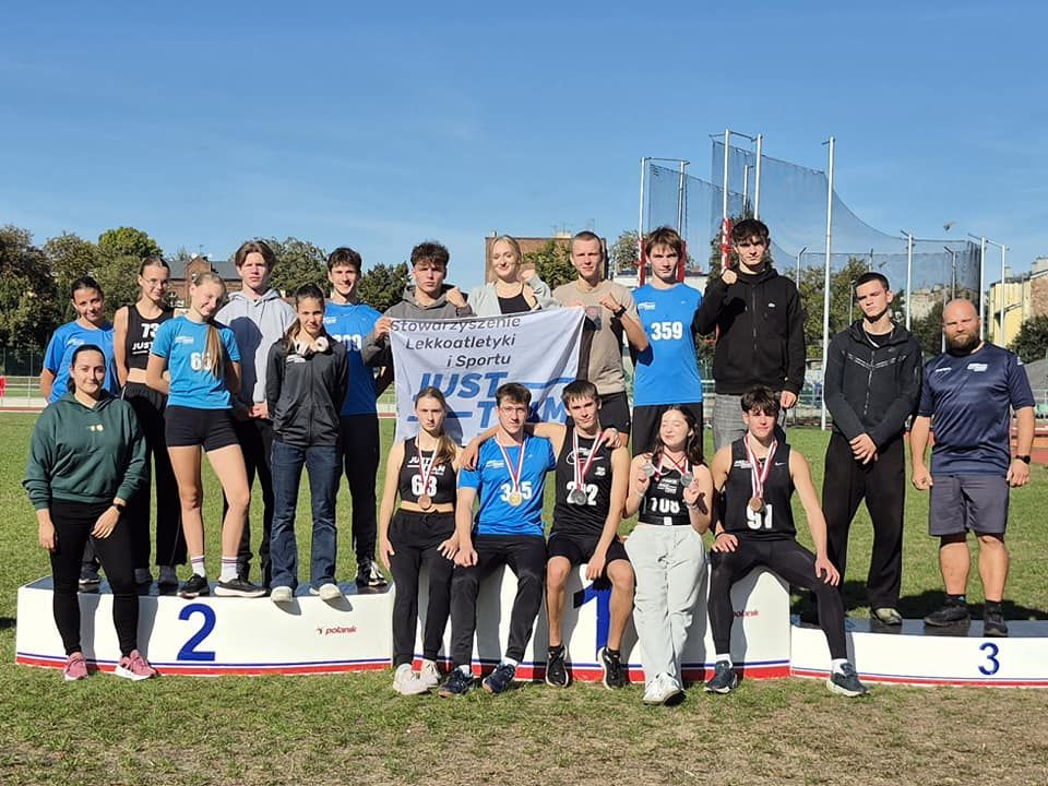 Na zdjęciu stojący ludzie 