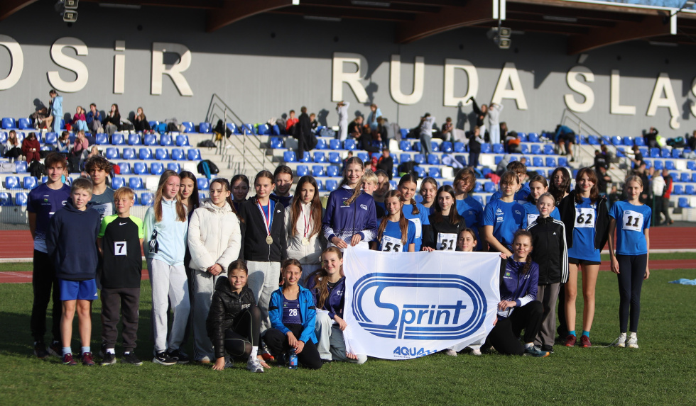 Na zdjęciu stojący ludzie 