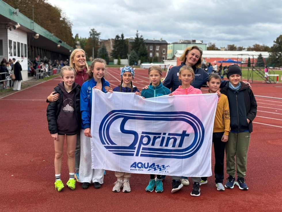 Na zdjęciu stojący ludzie 