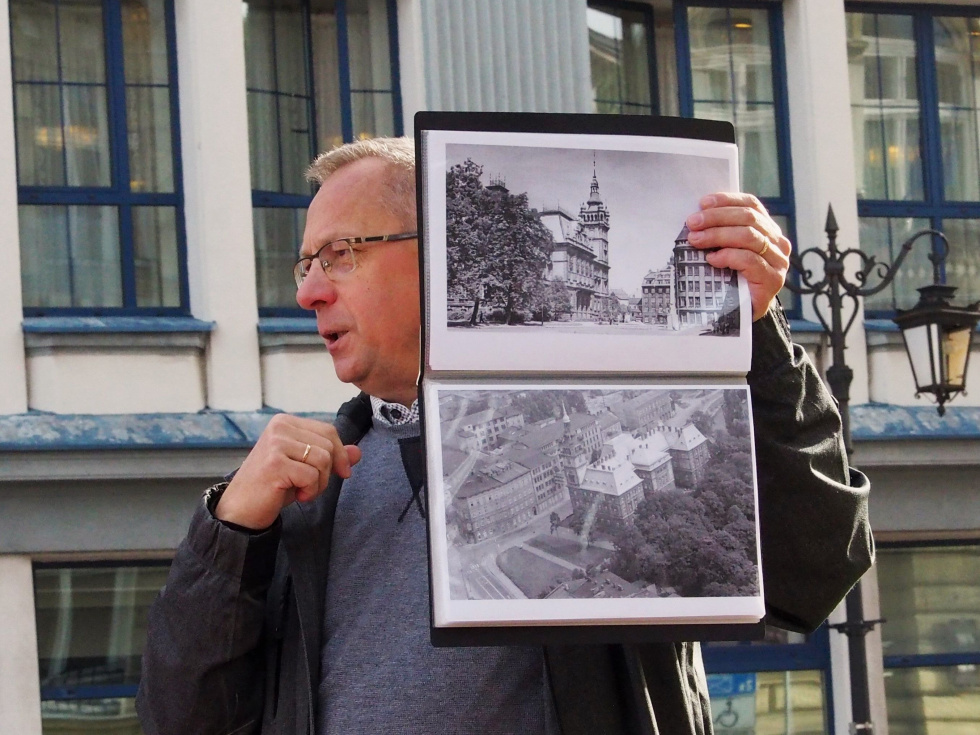 Na zdjęciu stojący ludzie 