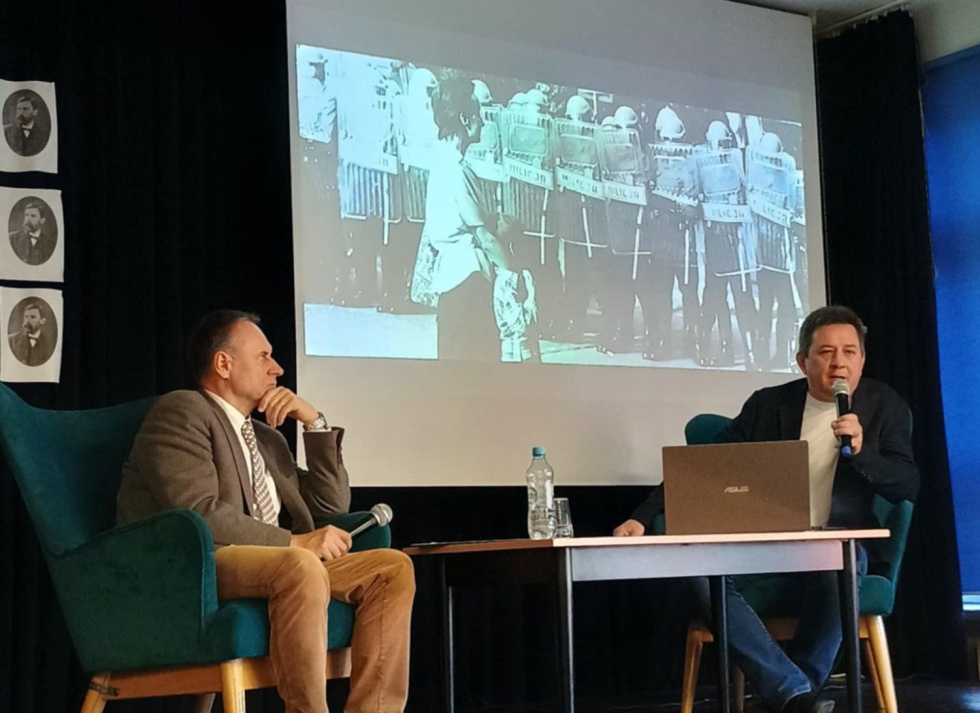 Na zdjęciu siedzący ludzie 